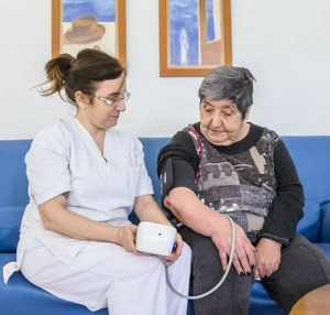 Geriatric nurse takes care of an older woman as part of nursing follow-up in a geriatric center.