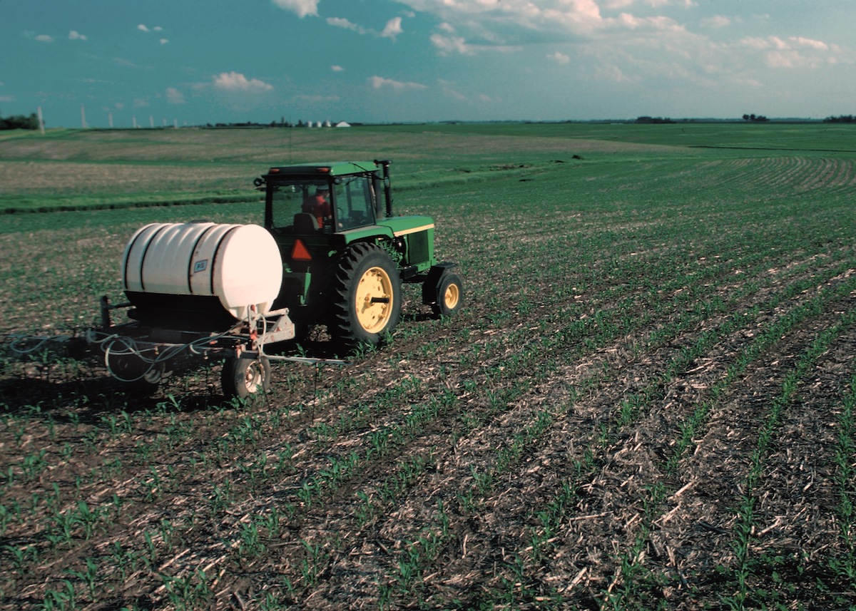 How reporter Yanqi Xu connected nitrate pollution to pediatric cancer. Tractor applying fertilizer to field