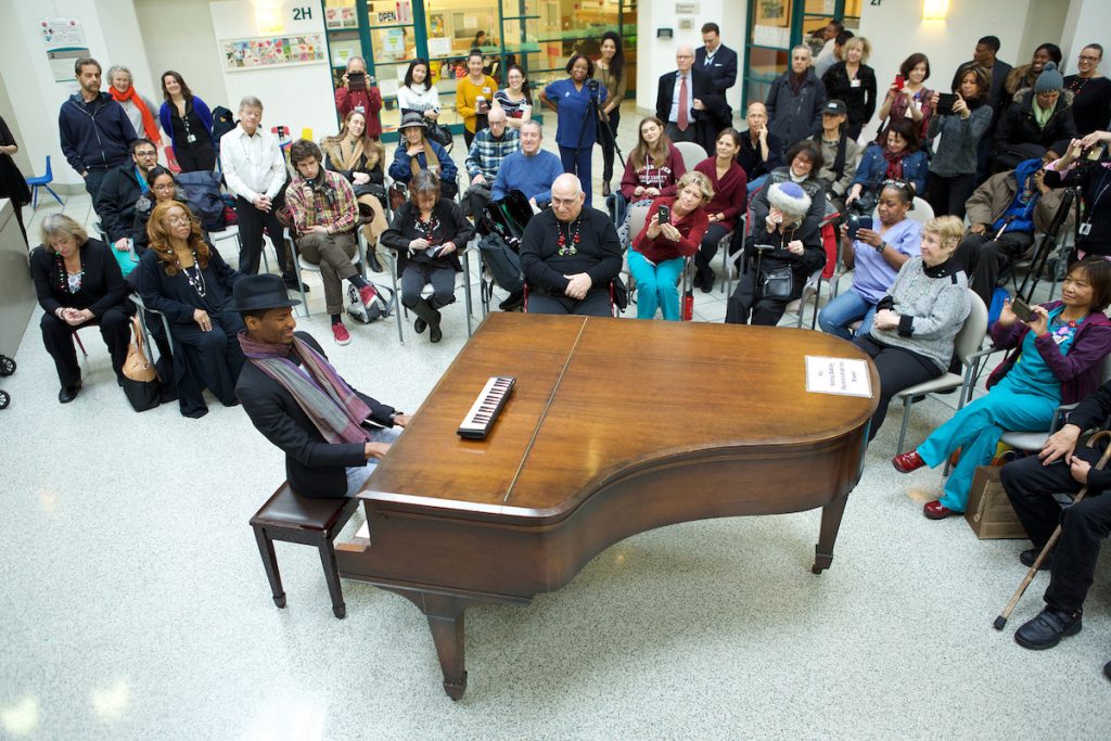 Jon Batiste plays piano at Mount Sinai Louis Armstrong Department of Music and Medicine