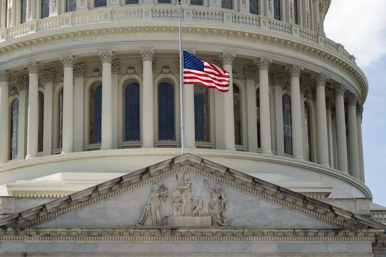 capitol building with flag at half mast in foreground. gun violence featured image