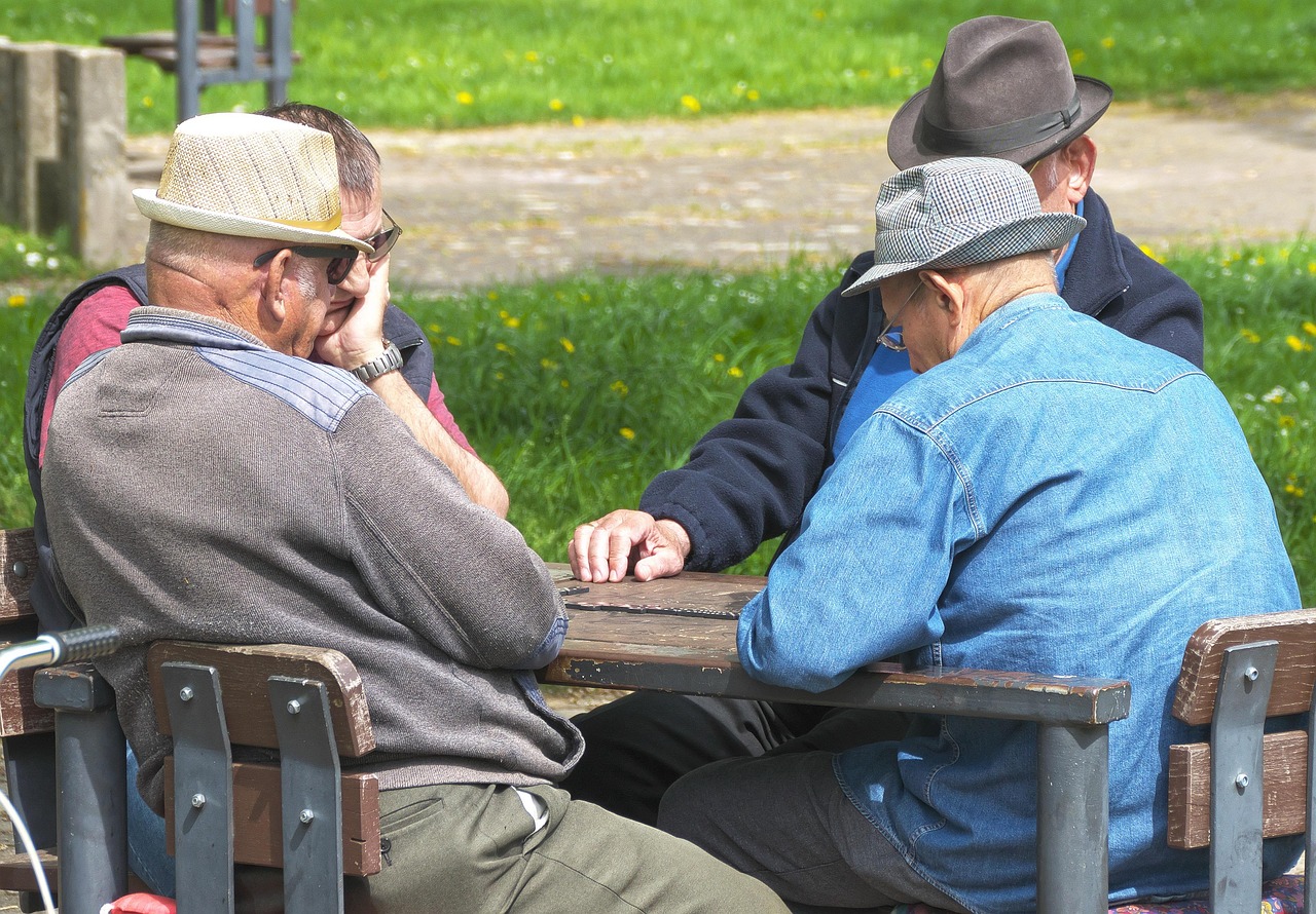 older adults playing dominoes at a table | longevity featured image