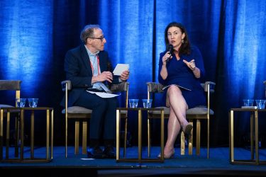 Gideon Gil moderates a talk with the Trump administration's Stephanie Carlton on stage at HJ25