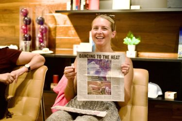 Journalist Anna Medaris holds up a newspaper clipping of a recent article she wrote.
