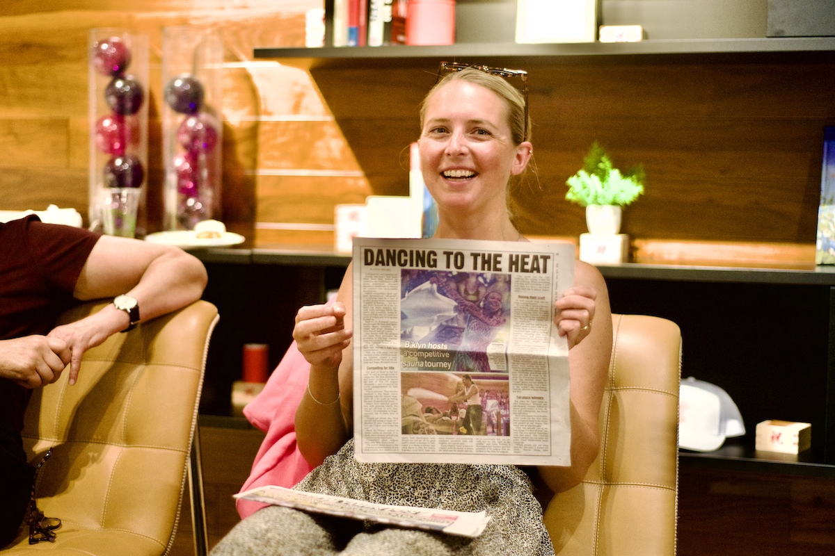 Journalist Anna Medaris holds up a newspaper clipping of a recent article she wrote.