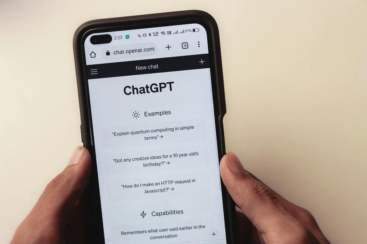 A person holding a phone with ChatGPT pulled up on the screen