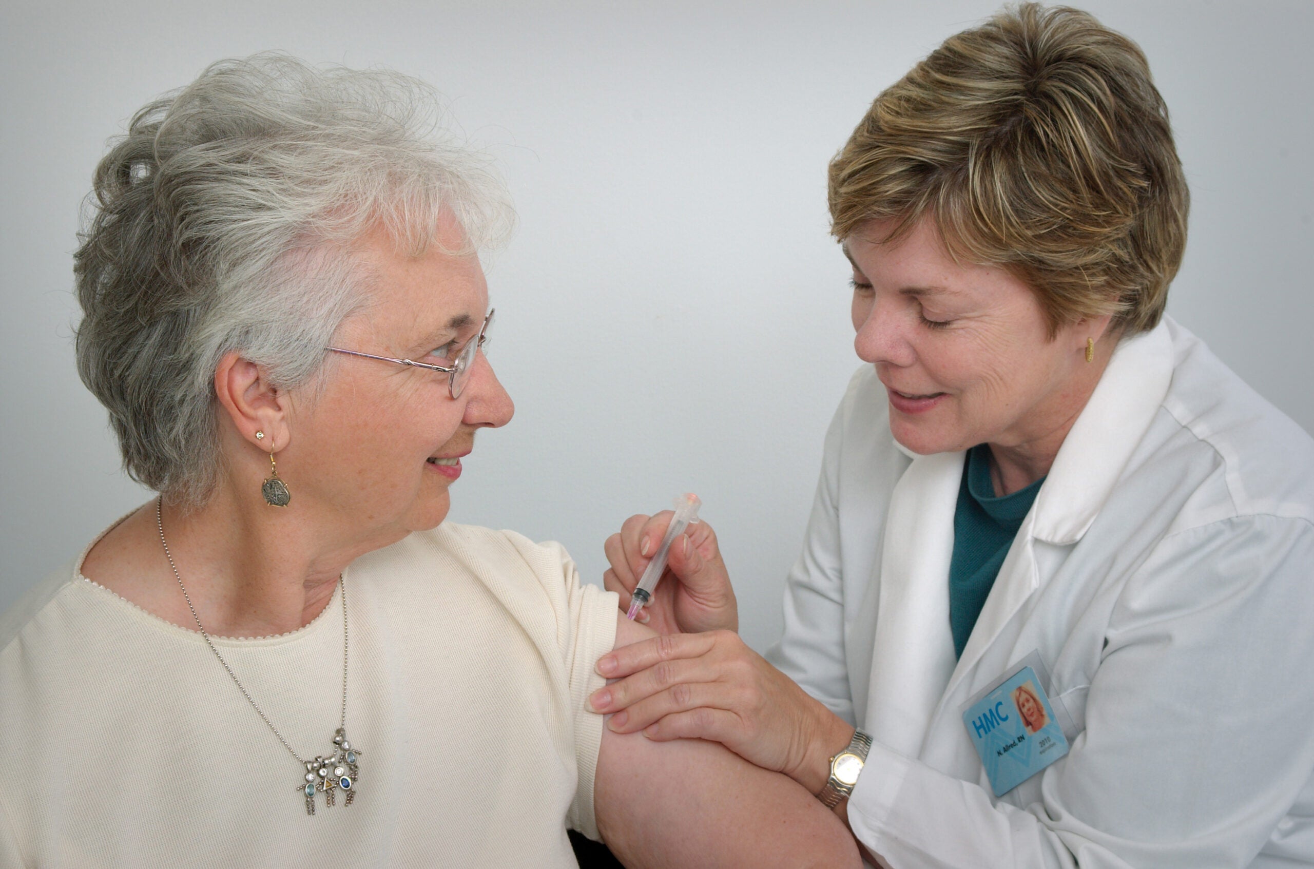 A woman receives a vaccine from a health care professional. RSV vaccine featured img