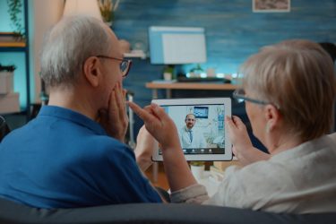 an older man and woman using telehealth