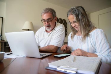 An older couple choosing a Medicare plan on a computer