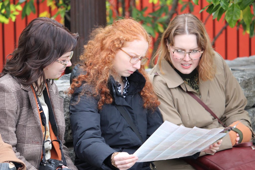 Three journalists look at a map of Roosevelt Island during a guided tour at AHCJ's 2025 fall summit. Photo by Kevin Ridder