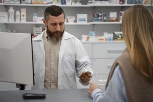 a pharmacist consults a patient at a drug store.