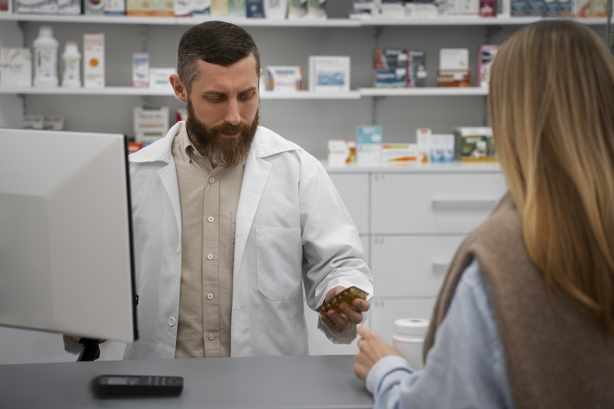 a pharmacist consults a patient at a drug store.