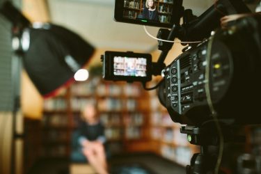 broadcast journalist talking to a camera