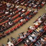 a birds-eye view of an audience in an auditorium. gun violence prevention summit featured image