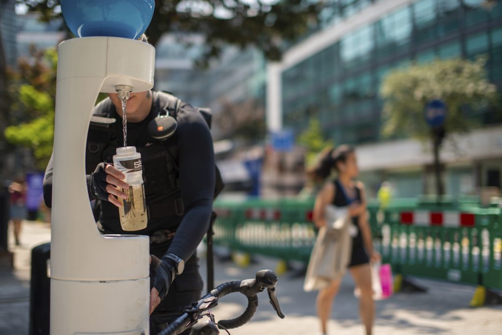 person refilling their water bottle in extreme heat