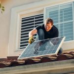 person installing solar panel. climate featured image