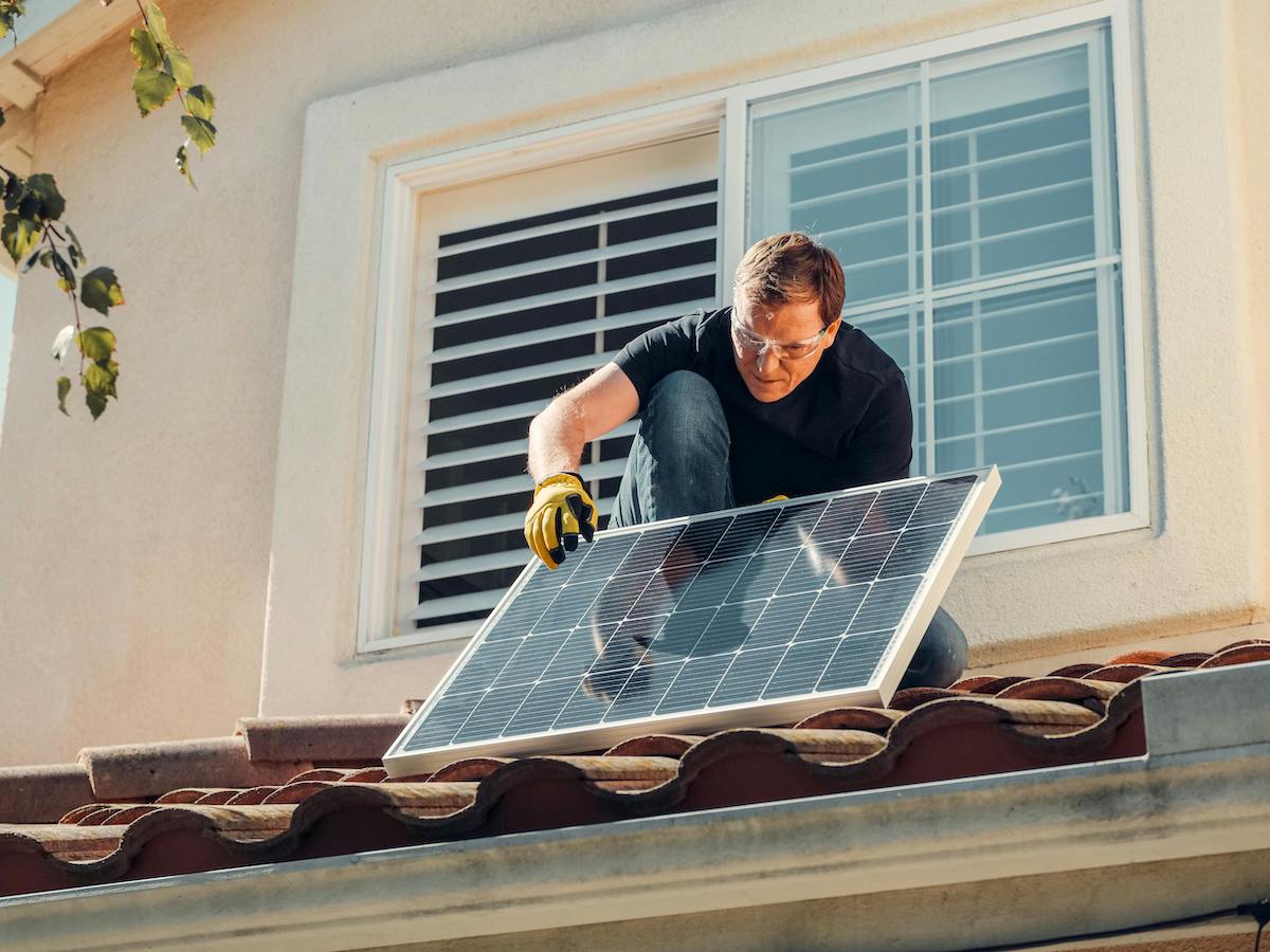 person installing solar panel. climate featured image