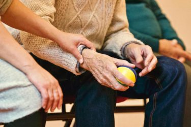 older adult holding a stress ball. aging featured image
