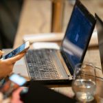 person holding a smartphone using a computer. gun violence featured image
