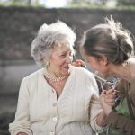 An older woman talking to a younger woman outside. Medicaid HCBS featured photo