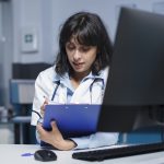 practioner writing on a clipboard