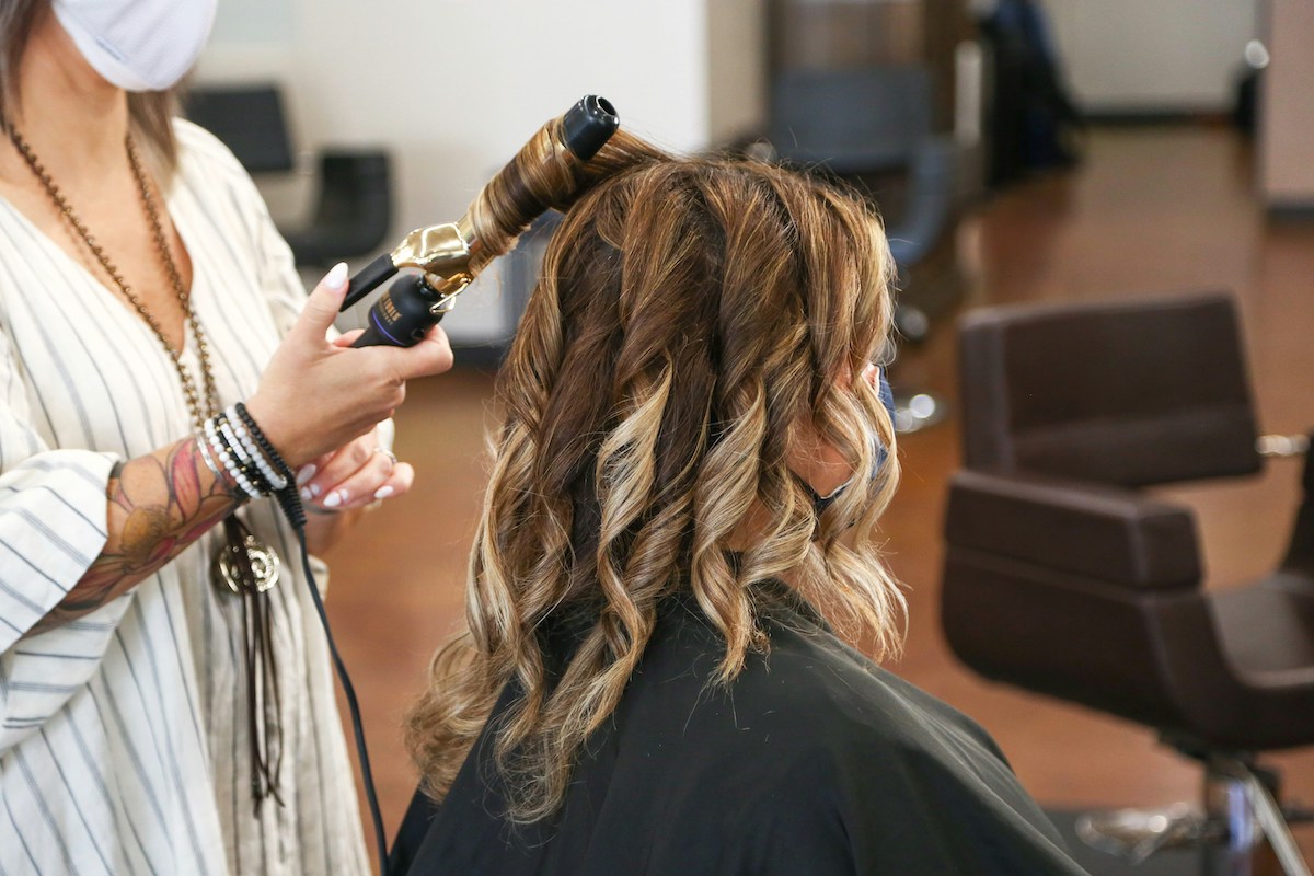 woman at a hair salon getting hair curled. New research shows there are toxic chemicals in hair extensions.