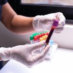 person holding a blood sample in a glass tube