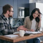 couple paying overdue bills with high deductibles