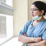 female nurse staring out window. health disparities featured img