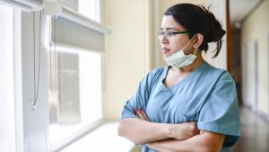 female nurse staring out window. health disparities featured img