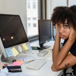 frustrated freelance journalist with her head in her hands