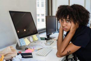 frustrated freelance journalist with her head in her hands