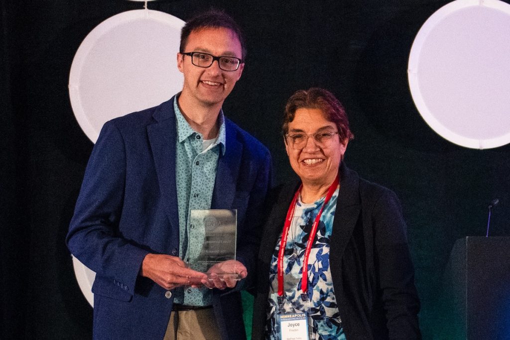 Bob Herman, holding the inaugural Sunshine Award, standing next to Joyce Frieden.