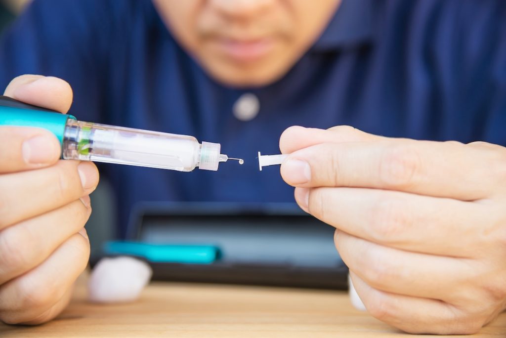 man preparing a semaglutide injection