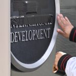 A person tapes over a USAID sign at the agency's main entrance in Washington, D.C., in February 2025.