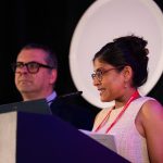AHCJ Contest Committee Co-Chair Renuka Rayasam announces winners at HJ26 next to Committee Co-Chair Jonathan Rockoff. Photo by Zachary Linhares