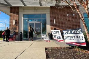 Voting signs outside of a polling location. The signs say "VOTE HERE DISTRICT 12" and "VOTE HERE DISTRICT 5"