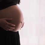 Pregnant woman holding her belly. Taking the Tdap vaccine during pregnancy is still the most effective way to prevent whooping cough in infants.