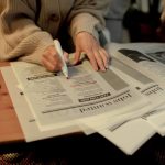 a person who was laid off searching a newspaper classifieds