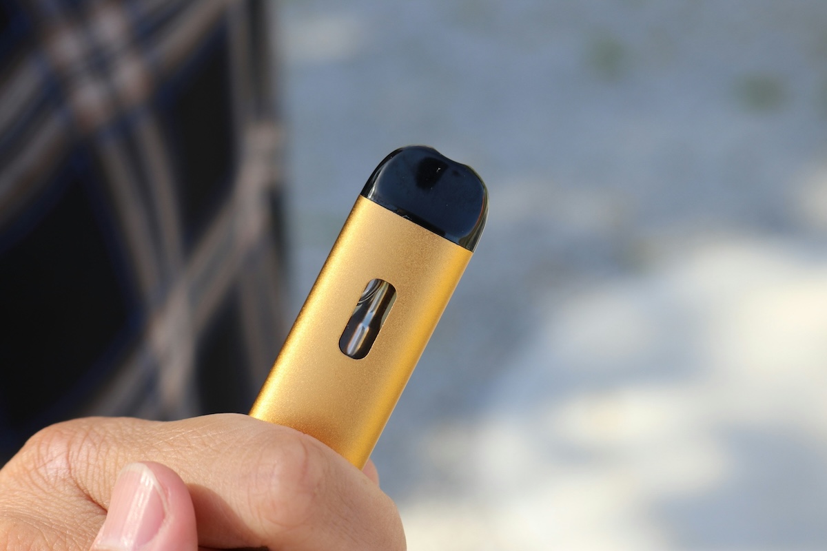 a hand holding a vape pen for vaping