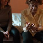 an older woman and her daughter. the older woman is looking at her wedding ring sadly. nursing home oversight
