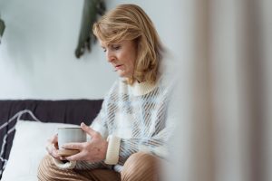 an older woman holding a mug